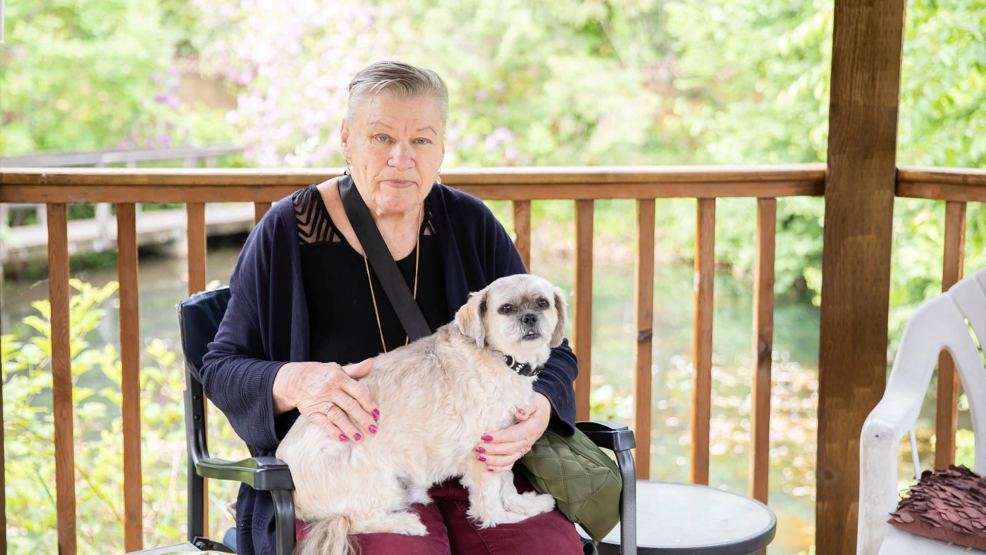 Senior woman sitting in a gazebo with a dog on her lap